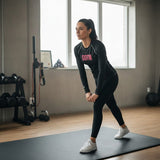 Roll Gear Women's black long-sleeve BJJ rash guard with pink GOTM logo and text on sleeves, worn by a woman in a gym.