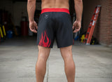 Roll Gear LLC black grappling shorts with red flame design and red waistband. Designed for training and mobility.