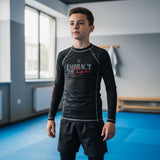 Roll Gear black youth performance long sleeve rash guard with "Embrace the Chaos" graphic and red accents on sleeves.