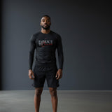 Roll Gear Embrace the Chaos Rash Guard – Black – Men’s, front view, worn with black shorts in a studio.